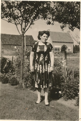 1952 Mieneke Spanjaards in de tuin van haar huis . Op de achtergrond de schuur en het nieuwe huis fam. Noy.
